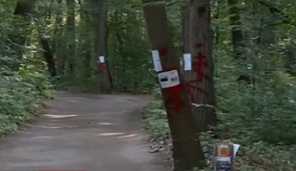 Мъжът който размахва пистолет и рисува кървави кръстове върху дърветата